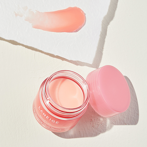 An open jar if the laneige lip sleeping mask with the lid kept atop ots side and a piece of paper with a swab of the product on it above the product: the last step to prep your skin for flawless make up